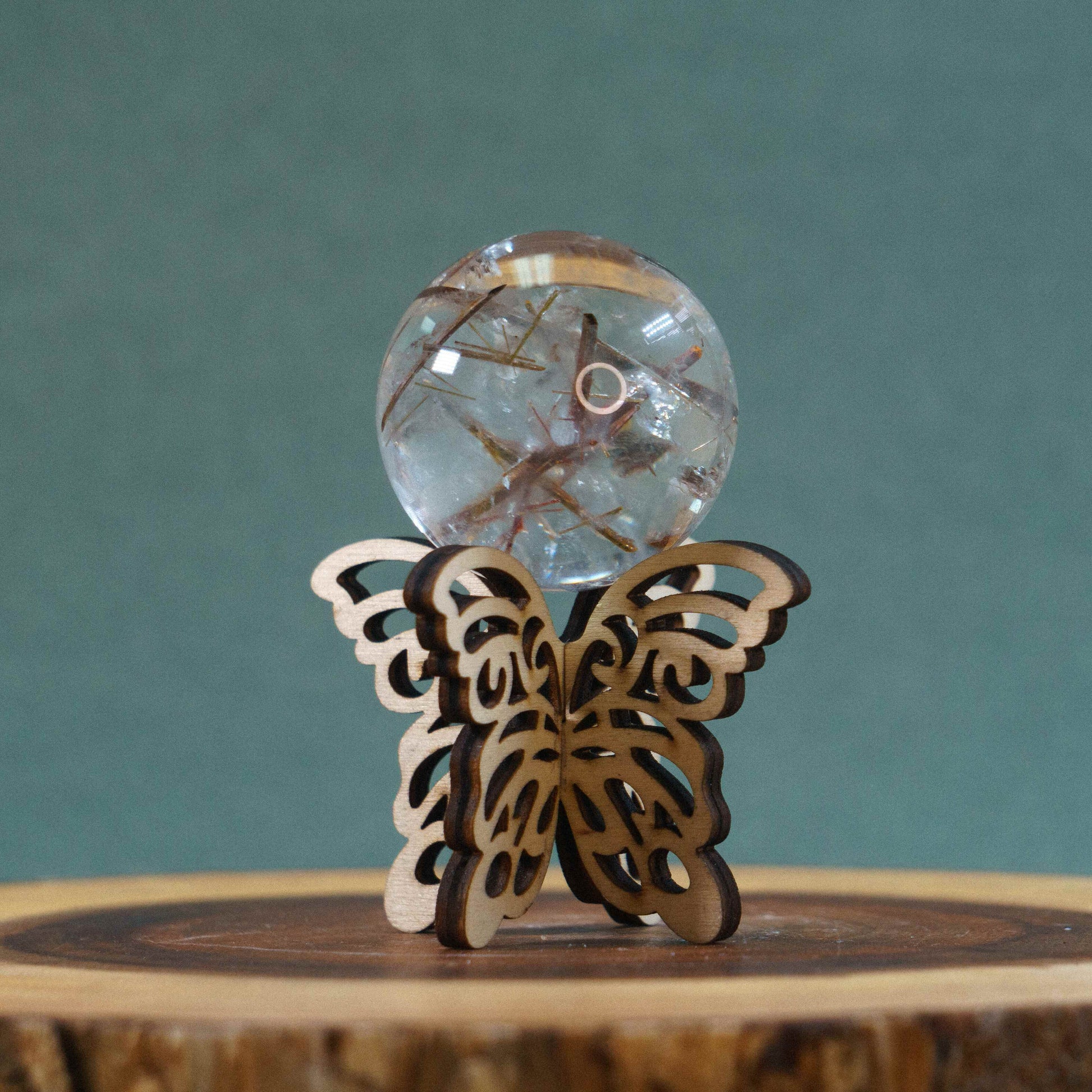 clear crystal sphere on a wooden 3D butterfly stand 